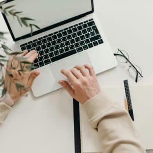 Free An overhead view of a person working on a laptop in a minimalist home office setting. Stock Photo