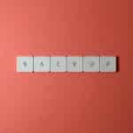 Free Close-up of keyboard keys spelling 'BACKUP' placed on a coral-colored surface. Stock Photo