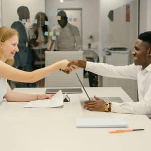 Free Business professionals completing a successful deal with a handshake in a modern office setting. Stock Photo